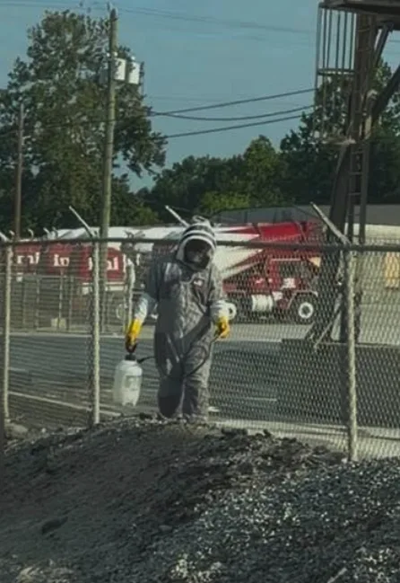 derrek pendergraff walking in commercial yard with pest control chemicals in hand
